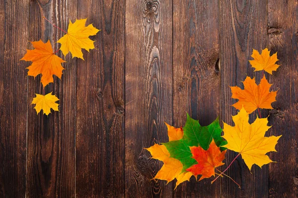 Quadro de folhas de bordo de outono em um fundo de madeira. Design e espaço para texto — Fotografia de Stock