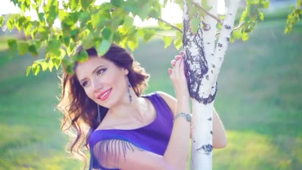 Красива молода жінка біля березових дерев у парку — стокове відео
