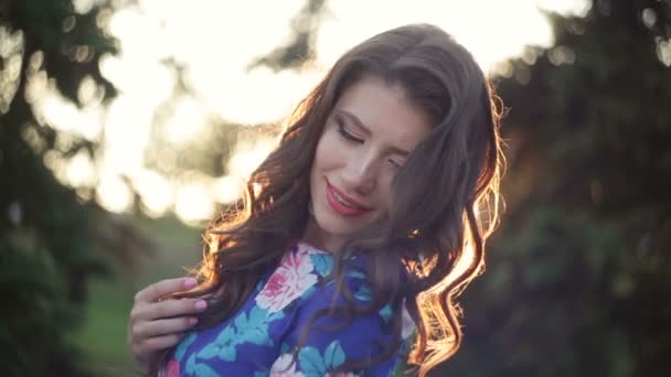 Hermosa joven posando contra el sol poniente — Vídeo de stock