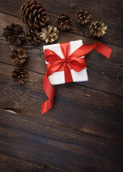 Caja de regalo con cinta roja sobre fondo de madera — Foto de Stock