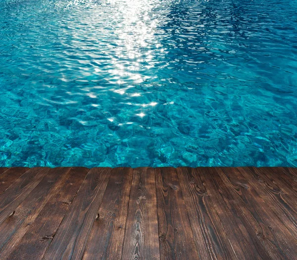 Textuur van het water in het zwembad en plek voor tekst op een houten achtergrond — Stockfoto