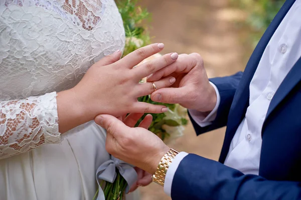 Noivo veste o anel de noiva em seu dedo — Fotografia de Stock