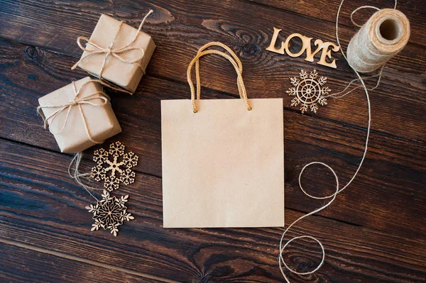 Burla Bolsa de papel de papel kraft y cajas de regalo de Navidad sobre un fondo de madera — Foto de Stock
