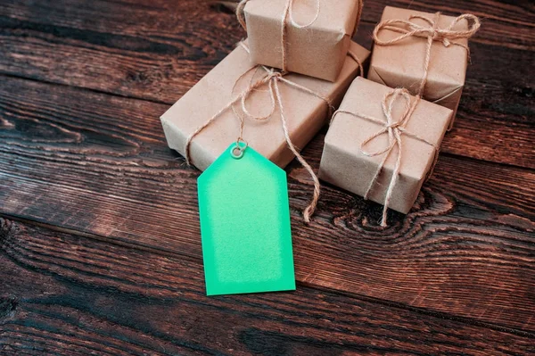 Mockup vakken voor giften van kraftpapier en gift tags op een houten achtergrond — Stockfoto