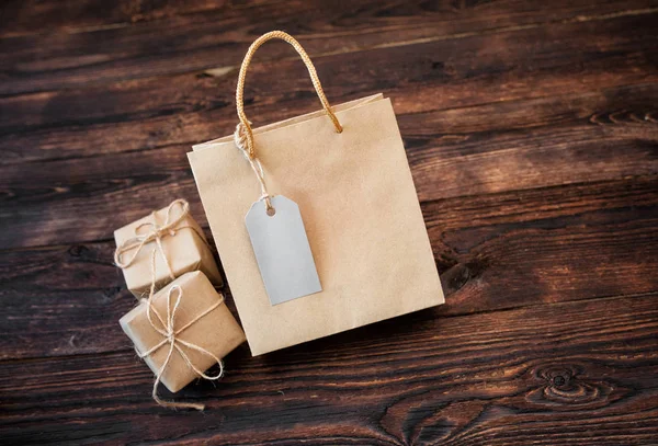 Mockup kraft carton gift box and handle package on wood background for design, website, background — Stockfoto