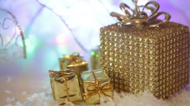 Kar ve kurdele ile altın hediye kutuları. Kış tatili, soyut bokeh parlak parlayan ile mevcut ışık arka plan bulanıklık Noel dekorasyon