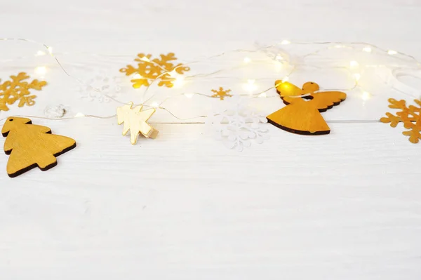 Composizione natalizia con un albero di Natale dorato, ghirlanda e un angelo su uno sfondo di legno bianco. Flat lay vista dall'alto foto mockup — Foto Stock