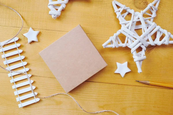 Fond de Noël boîte kraft avec place pour votre texte et fond en bois étoile de Noël blanc. Pose plate, top vue photo maquette — Photo