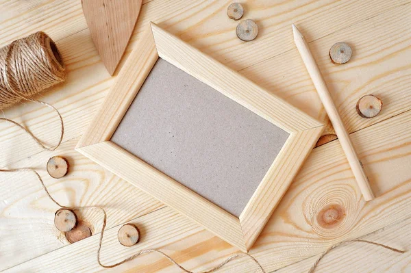 Light wooden frame on a wooden background. Flat lay, top view photo mockup — Stock Photo, Image