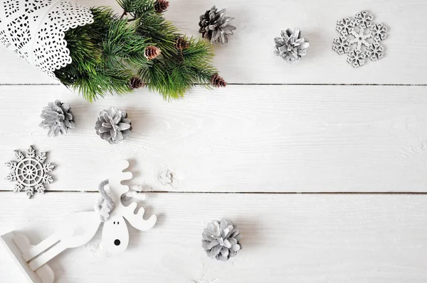 Weihnachts-Attrappe auf weißem Holzgrund mit Schneeflocken, einem Hirsch und einem Weihnachtsbaum. flache Lage, Draufsicht — Stockfoto