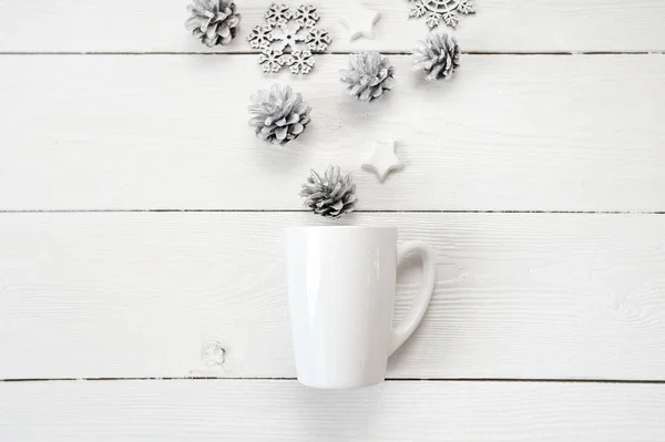 Mockup vit kopp med jul kottar och stjärnor, på en vit trä bakgrund. Platt lekmanna, top Visa foto mock upp — Stockfoto