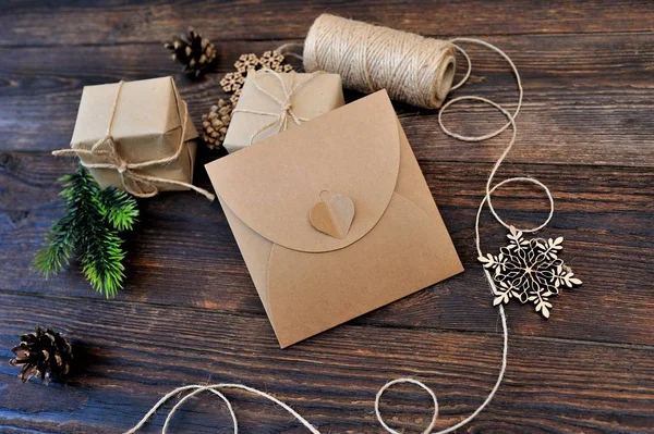 Χριστουγεννιάτικη σύνθεση σύνολο Κραφτ κουτιά δώρων, παιχνίδια κλωστοϋφαντουργίας και σχοινί σε φόντο ξύλινη — Φωτογραφία Αρχείου