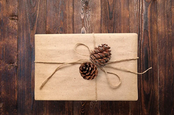 Jul eller nyår presenterar presentbox med kottar på en trä naturlig varm vit yta vy från ovan. Närbild med urklippsbana — Stockfoto