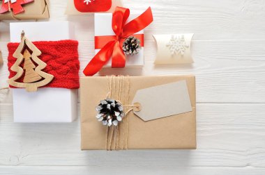 Mockup Noel kompozisyon. Noel hediyesi, etiket örgü battaniye, çam kozalakları, çam dalları ahşap beyaz zemin üzerinde. Düz yatıyordu, en iyi görünümü