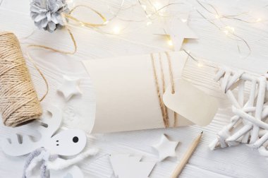 Mockup Noel tebrik kartı bonbonniere ve etiket üstten görünüm, flatlay çelenk ile beyaz ahşap zemin üzerinde