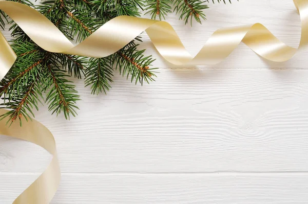 Mockup árvore de Natal e fita de ouro, flatlay em um fundo de madeira branca, com lugar para o seu texto — Fotografia de Stock