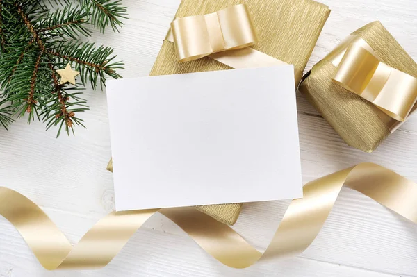 Mockup Weihnachtsgrußkarte mit goldenem Geschenkband, Flatlay auf weißem Holzgrund, mit Platz für Ihren Text — Stockfoto