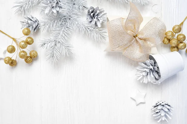 Mockup Noel Hediyelik altın yay ve ağaç koni, metniniz için yer ile beyaz ahşap zemin üzerinde flatlay — Stok fotoğraf