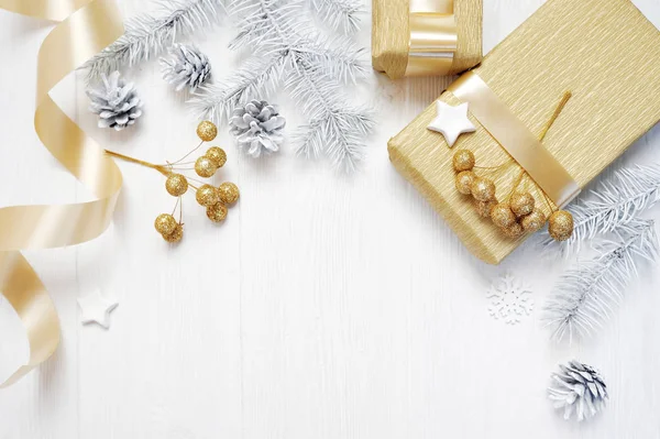 Mockup presente de Natal fita de arco de ouro e cone de árvore, flatlay em um fundo de madeira branca, com lugar para o seu texto — Fotografia de Stock