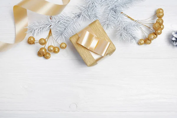 Mockup Weihnachtsgeschenk Goldschleife und Baumkegel, flach auf weißem Holzhintergrund, mit Platz für Ihren Text — Stockfoto