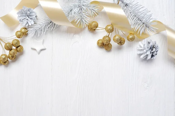 Mockup Noel Hediyelik altın yay şerit ve ağaç koni, metniniz için yer ile beyaz ahşap zemin üzerinde flatlay — Stok fotoğraf