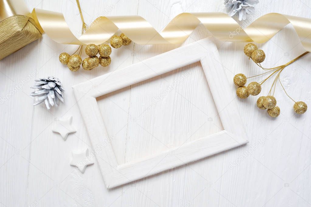 Mockup Christmas wood frame gold bow ribbon and tree cone, flatlay on a white wooden background, with place for your text
