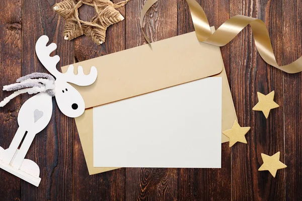 Noel mockup zarf boş kağıt üzerinde kahverengi ahşap zemin ile. Noel Baba'ya mektup. Noel kış ayarı - yıldız, elk, şerit — Stok fotoğraf