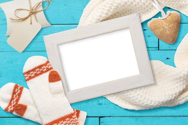 Mockup christmas white frame mit gestrickten Fäustlingen, flach auf weißem Holzhintergrund mit Schleife, mit Platz für Ihren Text — Stockfoto