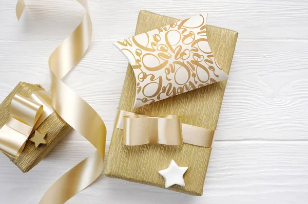 Mockup Navidad tarjeta de felicitación texto Hohoho con cinta de regalo de oro, flatlay sobre un fondo de madera blanca — Foto de Stock