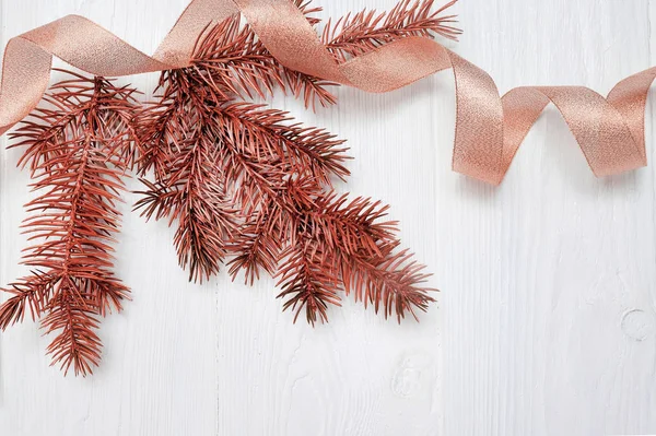 Mockup Christmas tree branch and gold gift ribbon, flatlay on a white wooden background, with place for your text — Stock Photo, Image