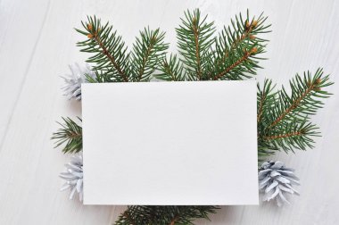 Ağaç ve koni, metniniz için yer ile beyaz ahşap zemin üzerinde flatlay mockup Noel tebrik kartı