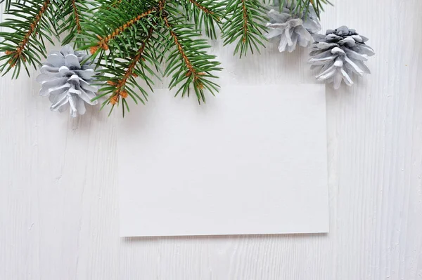 Mockup Tarjeta de felicitación de Navidad con árbol y cono, flatlay sobre un fondo de madera blanca, con lugar para su texto — Foto de Stock