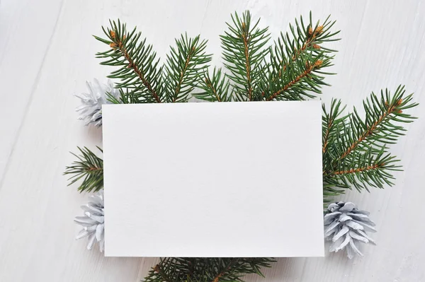 Makieta świąteczne z życzeniami z drzewa i stożek, flatlay na białym tle drewnianych, z miejscem na Twój tekst — Zdjęcie stockowe