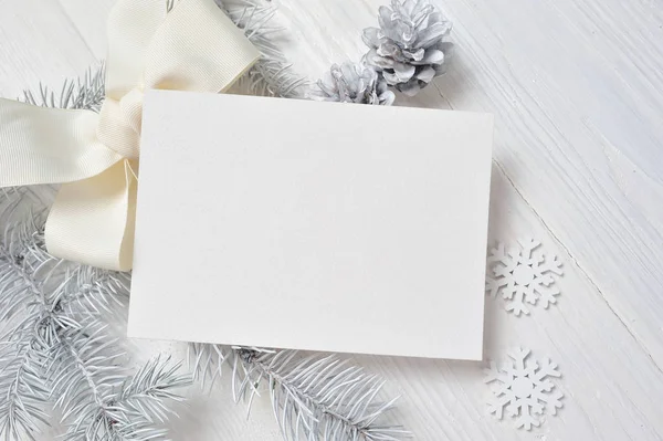 Mockup Tarjeta de felicitación de Navidad con árbol blanco y cono, flatlay sobre un fondo de madera blanca, con lugar para su texto — Foto de Stock