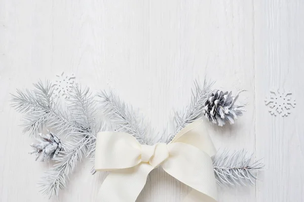 Mockup Natal árvore branca e cone, laço de fita. Flatlay em um fundo de madeira branco, com lugar para o seu texto — Fotografia de Stock