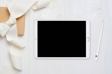 Mockup tablet bilgisayar ve kalem eski ahşap tablo, metniniz için yer ile beyaz ahşap zemin üzerinde flatlay. Düz yatıyordu, en iyi görünümü fotoğraf kadar sahte