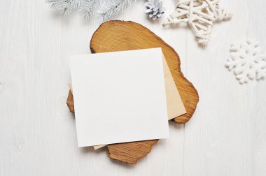 Mockup Noel tebrik kartı mektup zarfı beyaz ağaç, metniniz için yer ile beyaz ahşap zemin üzerinde flatlay