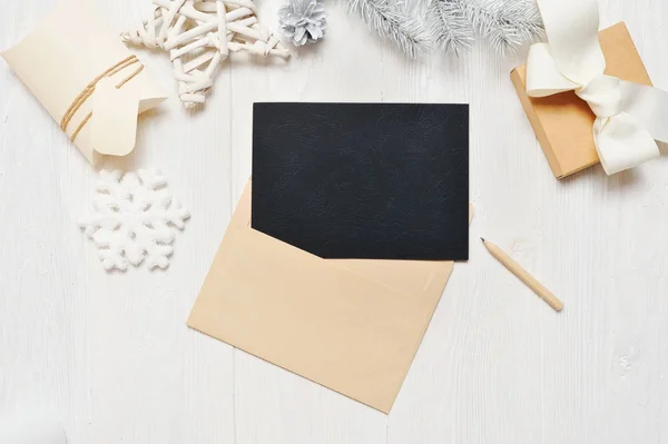 Maketa Vánoční blahopřání černé dopis v obálce a tužka, flatlay na bílém pozadí, které dřevěné pozadí, místo pro váš text, ploché, pohled shora Foto mock-up — Stock fotografie