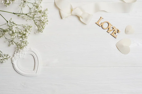 Mock up Composition of white flowers rustic style, hearts love and a gift for St. Valentines Day with a place for your text. Flat lay, top view photo mock up