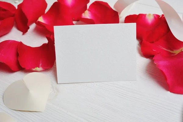 Makieta kwiaty skład serca list płatkami róż czerwony na białym tle drewnianych. Walentynki. Widok płaski świeckich, top z miejscem na Twój tekst — Zdjęcie stockowe