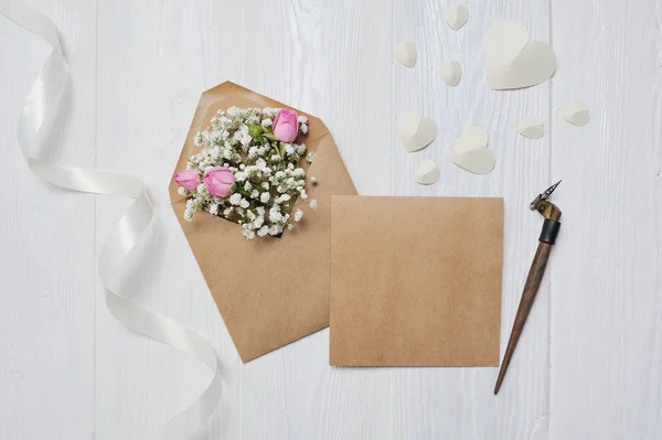 Maqueta Carta con flores y tarjeta de felicitación de la pluma caligráfica para el día de San Valentín en estilo rústico con lugar para su texto, plano laico, vista superior foto maqueta — Foto de Stock