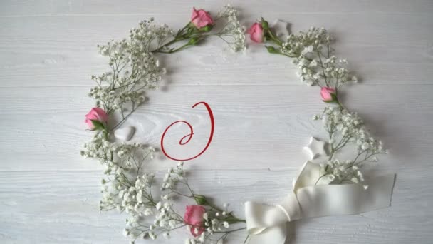 Joy Vintage Written animation word on round wreath with branch on white wooden background. Calligraphy and lettering flourish elements for Valentines Day wedding or other holidays — Stock Video