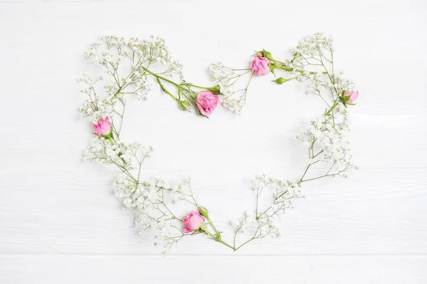 Mock up Composition heart of white flowers rustic style, for St. Valentines Day with a place for your text. Flat lay, top view photo mock up
