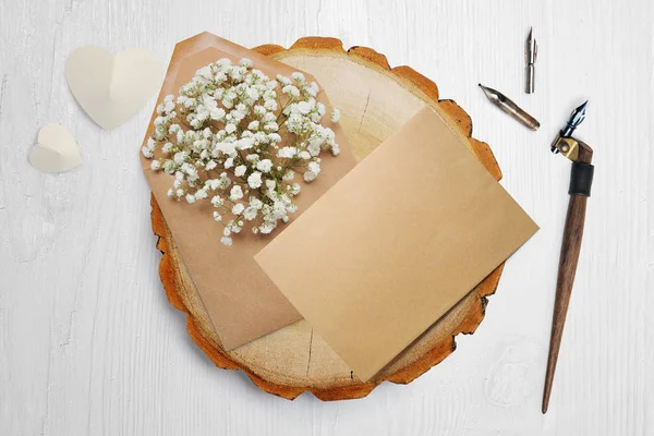 Pluma caligráfica, se encuentra cerca de un círculo de madera con un corazón de papel blanco. tarjeta de felicitación para el día de San Valentín con lugar para su texto. Flat lay, maqueta de fotos vista superior — Foto de Stock