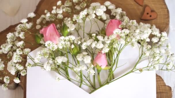 Kraft koperty z kwiatami na drewniane białe tło z długopisu kaligraficzne — Wideo stockowe