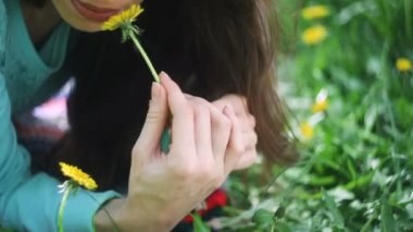 Güzellik kadını çayırda. Güzel genç kız açık havada. Doğa keyfini çıkarın. Kır çiçekleri ile yeşil çim üzerinde yalan sağlıklı gülümseyen kız. Gülmek ve mutlu