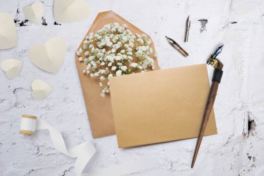 Kaligrafi tüy çiçek ve bir mektup, metniniz için yer ile Sevgililer günü tebrik kartı olan bir zarf. Düz yatıyordu, en iyi görünümü fotoğraf kadar sahte