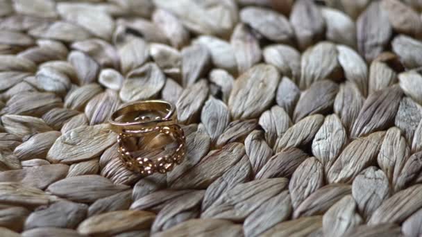 Video movie Wedding rings accessory lying on straw table. Close up. top view — Stock Video