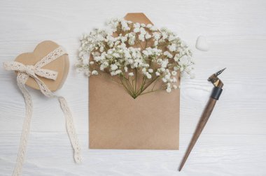 Kaligrafi tüy çiçek ve bir mektup, metniniz için yer ile Sevgililer günü tebrik kartı olan bir zarf. Düz yatıyordu, en iyi görünümü fotoğraf kadar sahte