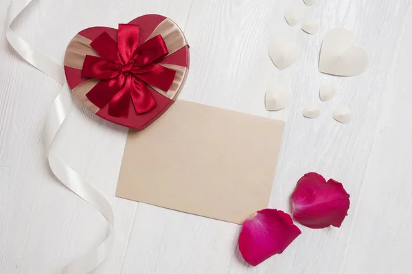 Makieta list z prezentem w postaci serca i płatki róży. z życzeniami na Walentynki z miejscem na tekst. Widok płaski świeckich, najlepsze zdjęcie makieta — Zdjęcie stockowe